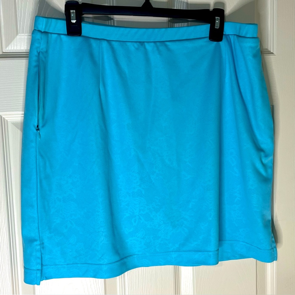 Monterey Club active style teal skort with faint floral pattern. 3 pockets